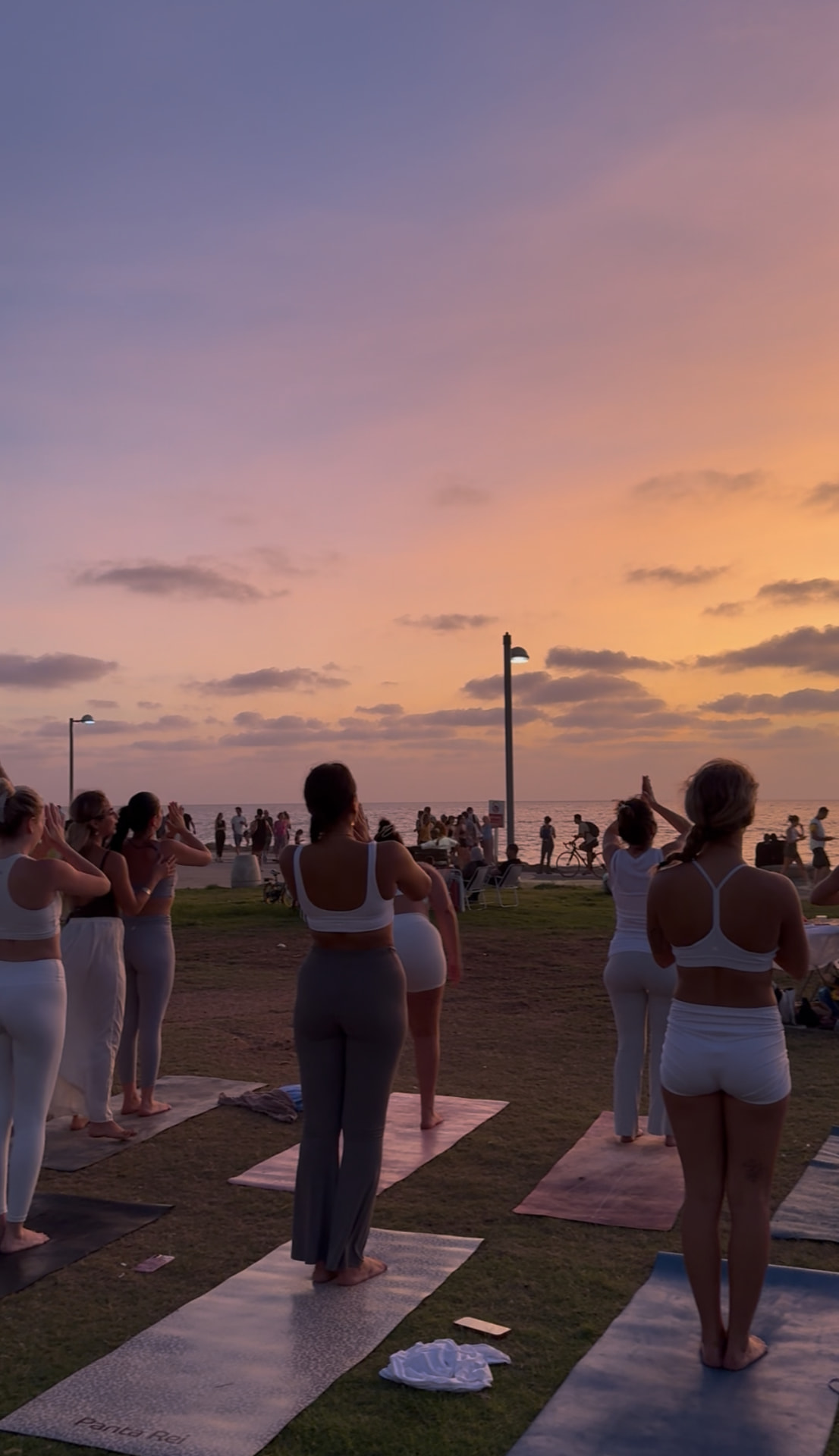 Sunset vinyasa yoga class on the grass by the sea